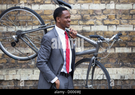 Portrait of African American businessman carrying Bicycle Stock Photo