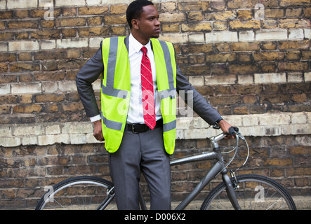 Portrait of African American businessman in safety vest with Bicycle Stock Photo