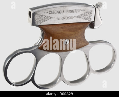 Shooting knuckle duster 'Chicago-Fighter',cal..22 long/short,no.2.Bright,rifled bore,length 55 mm.Pseudo proof mark crown/'N'.The upper part,which is finely engraved on both sides,has an integrated barrel marked 'CHICAGO-FIGHTER / Pat.070370'.Made of white-polished steel,trigger plates walnut-covered.Function: The ribbed hammer on a spring bearing on the upper part locks when it is pulled down and reveales the chamber.After pulling the opposite trigger the hammer shoots up and releases the shot.Mint condition.In Germany BKA exemption required.,Additional-Rights-Clearences-Not Available Stock Photo