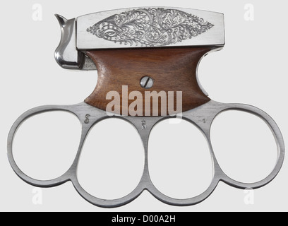 Shooting knuckle duster 'Chicago-Fighter',cal..22 long/short,no.2.Bright,rifled bore,length 55 mm.Pseudo proof mark crown/'N'.The upper part,which is finely engraved on both sides,has an integrated barrel marked 'CHICAGO-FIGHTER / Pat.070370'.Made of white-polished steel,trigger plates walnut-covered.Function: The ribbed hammer on a spring bearing on the upper part locks when it is pulled down and reveales the chamber.After pulling the opposite trigger the hammer shoots up and releases the shot.Mint condition.In Germany BKA exemption required.,Additional-Rights-Clearences-Not Available Stock Photo