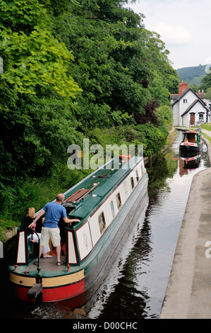 Holiday narrowboats pass on the Llangollen Canal at Wharf Hill, Llangollen, Denbighshire, Wales, UK Stock Photo