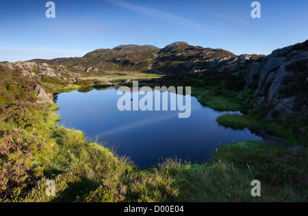 Sun rising over Innominate Tarn below the summit of Haystacks in the Lake district, England, UK. Stock Photo