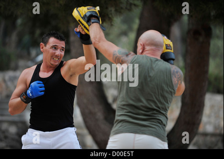 two men practice martial arts in a park Stock Photo
