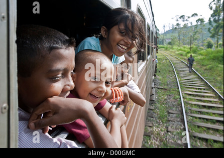 Children looking through the window. Colombo-Badulla line. Sri Lanka Stock Photo