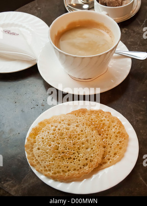 Two buttered Pikelets a regional version of crumpets a breakfast snack here served with coffee in North Yorkshire café tea room Stock Photo