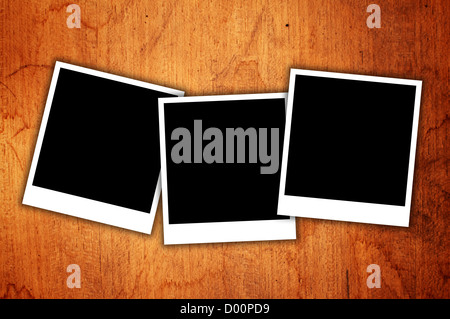 Blank photo frames over a wooden background Stock Photo