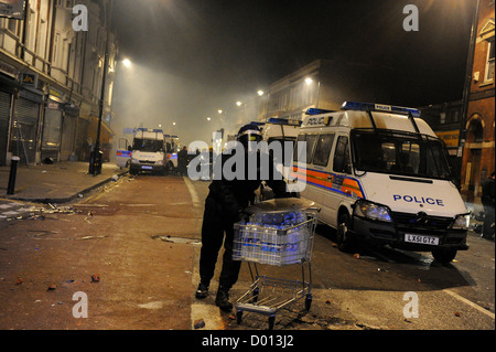 Policeman brings water to other Police Officers in Tottenham High Road Stock Photo