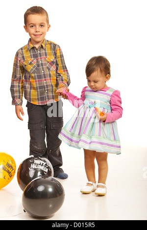 Walking kids holding their hands among Halloween balloons Stock Photo