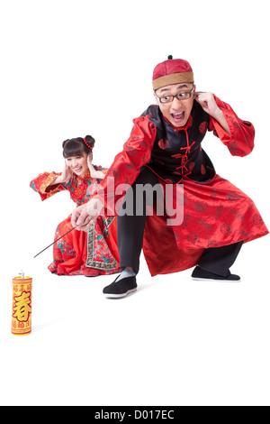 Happy young couple in Traditional clothing igniting firework Stock Photo
