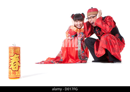 Happy young couple in Traditional clothing igniting firework Stock Photo