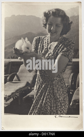 Eva Braun - four postcards, written to her parents and to her sister Ilse during the late 1930s: A photo postcard with Eva in summer dress at the Berghof, holding a rabbit and wearing the deluxe pendant in gold and diamonds (cf. lot T12517 in this auction sale) reading (tr) 'Dear parents! I wish you a happy Easter, health and joy.' people, 20th century, NS, National Socialism, Nazism, Third Reich, German Reich, Germany, German, National Socialist, Nazi, Nazi period, fascism, photograph, photo, photographs, photography, picture in frame, pictures, woman, women, , Stock Photo