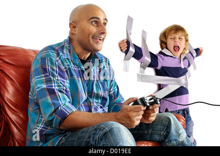 Young boy glued to the wall with duct tape, so daddy can play video games Stock Photo