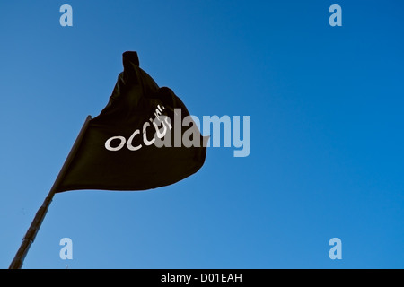 Black flag of Occupy movement flying above New York City's Union Square during protest against police brutality. Stock Photo