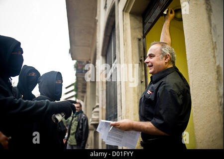 La Ramblas, Barcelona, Catalonia, Spain. 14th November 2012. Hooded pickets arguing with a worker to close an opened commerce. The general strike in Spain against welfare cuts and labor reform has changed the look of the crowd Rambla, the main tourist destination in the city of Barcelona. Credit:  Jordi Boixareu / Alamy Live News Stock Photo