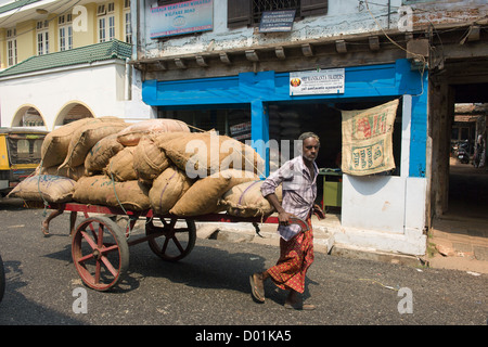 Man pulling a handcart loaded with jute sacks, Bazaar Road, Fort Cochin, Kochi (Cochin), Kerala, India Stock Photo