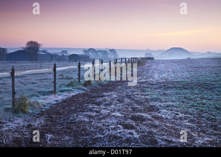 Frosty autumnal Wiltshire countryside landscape at twilight with iconic neolithic Silbury Hill in the distance Stock Photo