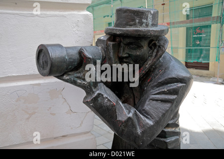 'Paparazzi' bronze sculpture, looking around a corner in the historic centre of Bratislava, Slovakia. Stock Photo