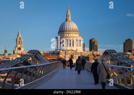 Commuters walking to work across the Millennium Bridge toward St. Paul's Cathedral, London England, UK Stock Photo