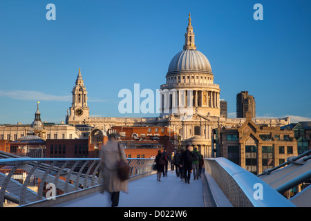 Commuters walking to work across the Millennium Bridge toward St. Paul's Cathedral, London England, UK Stock Photo