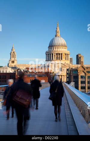 Commuters walking to work across the Millennium Bridge toward St. Paul's Cathedral, London England, UK Stock Photo