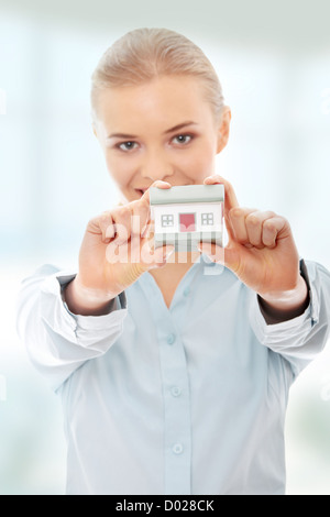Happy Businesswoman Holding House Model In Office Stock Photo - Alamy