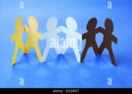 Row of Color Paper Chain figurines Holding Hands on Blue Background Stock Photo