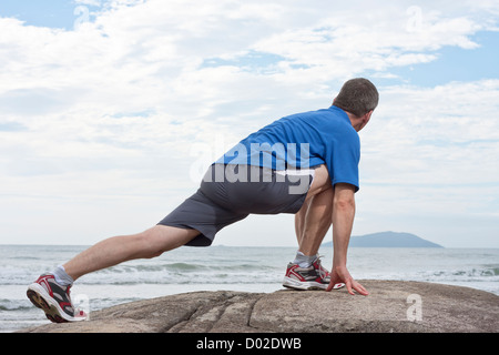 Runner doing stretching exercise Stock Photo