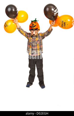 Boy with pumpkin hat and mask holding Halloween balloons isolated on white background Stock Photo