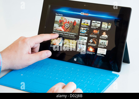 Man reading Sky news on Microsoft Surface rt tablet computer Stock Photo