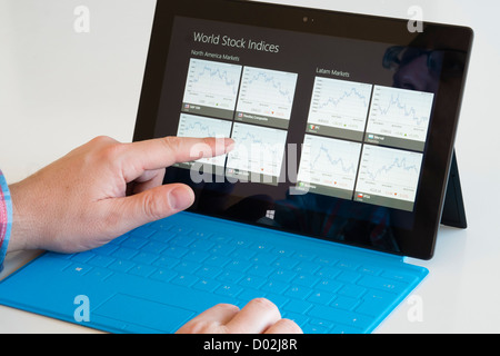 Man checking financial performance of markets on Microsoft Surface rt tablet computer Stock Photo
