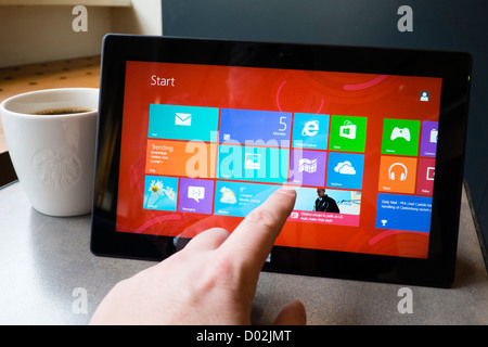 Man using Microsoft Surface rt tablet computer in cafe Stock Photo