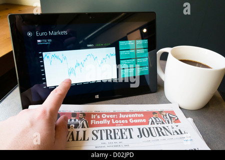 Man using Microsoft Surface rt tablet computer with business app to check stock market performance Stock Photo