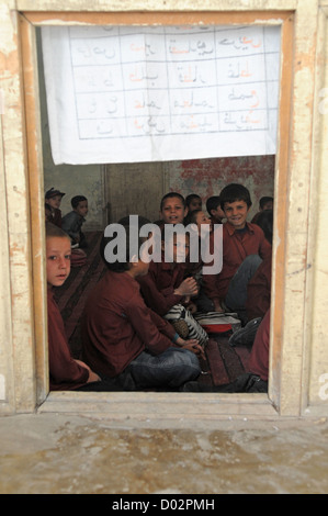 Afghan children at a boys school wait for a visit by members of the International Security Assistance Force September 18, 2008 in Kabul, Afghanistan. The ISAF helps the community by providing school supplies, clothing and food to local agencies in need. Stock Photo