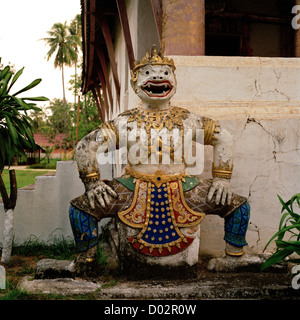 Demonic sculpture standing guard outside Buddhist temple Wat Aham in Luang Prabang in Laos in Indochina in Far East Southeast Asia. Demon Travel Stock Photo