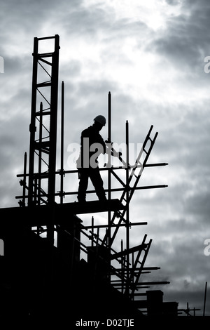 silhouette construction worker on scaffolding building site Stock Photo