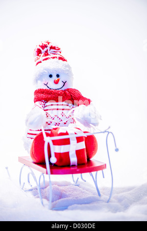 Happy snowman on sled with smiley face. Copy space. Stock Photo