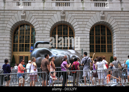 Tourists line up to have picture taken with the Wall Street Bull lower Manhattan New York City Stock Photo