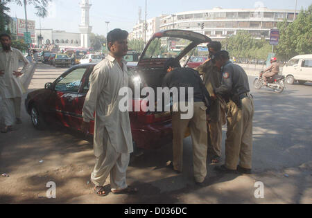 Police officials search car during snap checking at  Gurmander in Karachi on Thursday, November 15, 2012.As the security has been tightening all  over the province specially strict in Karachi on the arrival of Moharam-ul-Haram, Section 144  has also been imposed throughout Sindh up to November 15, 2012. Stock Photo