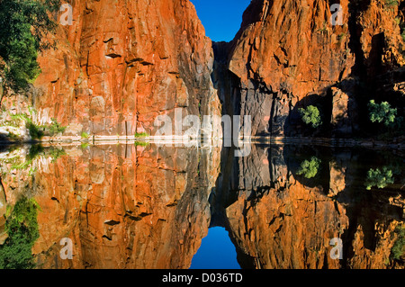 Red rock face reflecting in Python Pool. Stock Photo