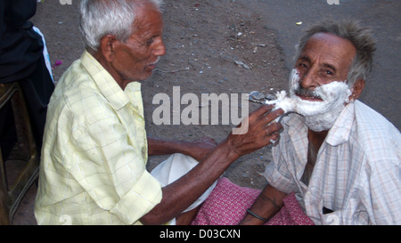 Man is shaved in street Jaipur Rajasthan India Stock Photo