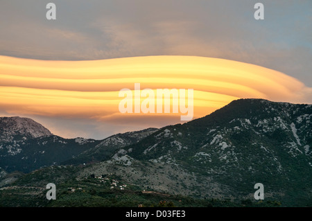 Lenticular clouds forming at sunset over the Taygetus mountains, in the Outer Mani, Peloponnese, Greece. Stock Photo