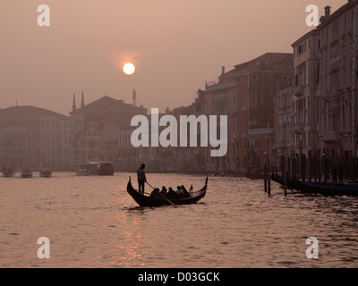 Gondolas and gondoliers on the Grand Canal  Venice Italy in Autumn mist at dusk sunset Stock Photo