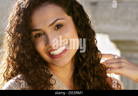Beautiful young woman with curly hair and happy smile Stock Photo