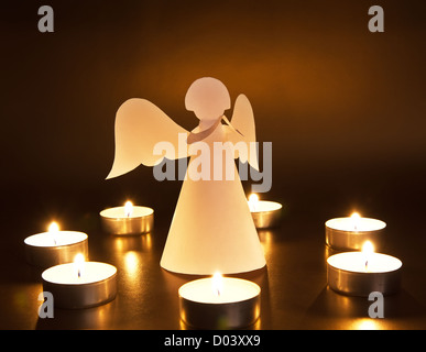 Christmas angel with candles over dark background Stock Photo
