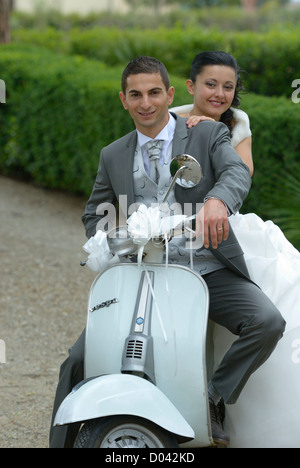 Italian wedding couple on a motor scooter Vespa, Firenze, Tuscany, Italy Stock Photo