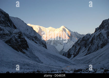sun on mountains of the snow covered Kang La pass in the Inner Dolpo region of western Nepal Stock Photo