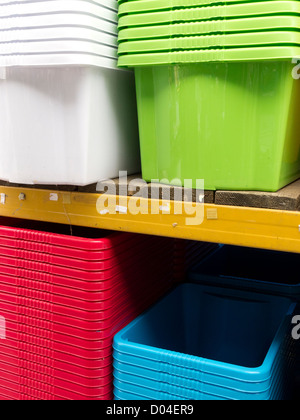 Colourful plastic crates stacked on display in shop. Stock Photo