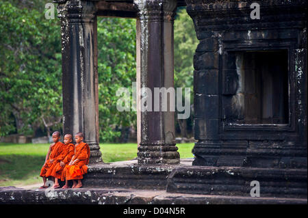 Siem Reap, Cambodia. 16th November 2012. Young Cambodian monks sit steps of Ankor Wat watching US Secretary of Defense Leon Panetta tour the landmark November 16, 2012 in Siem Reap, Cambodia Stock Photo