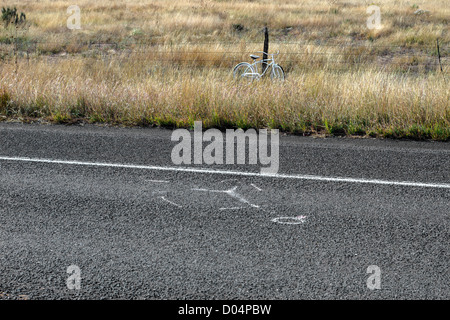 Forensic marks on a road and white bicycle called a White Ghost Bike, symbol of a cyclist death in the USA, near Marathon, Texas Stock Photo