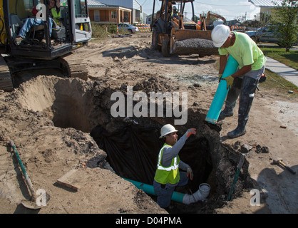 Seven years after Hurricane Katrina, workers hook up a sewer line to a new home in New Orleans' lower ninth ward. Stock Photo